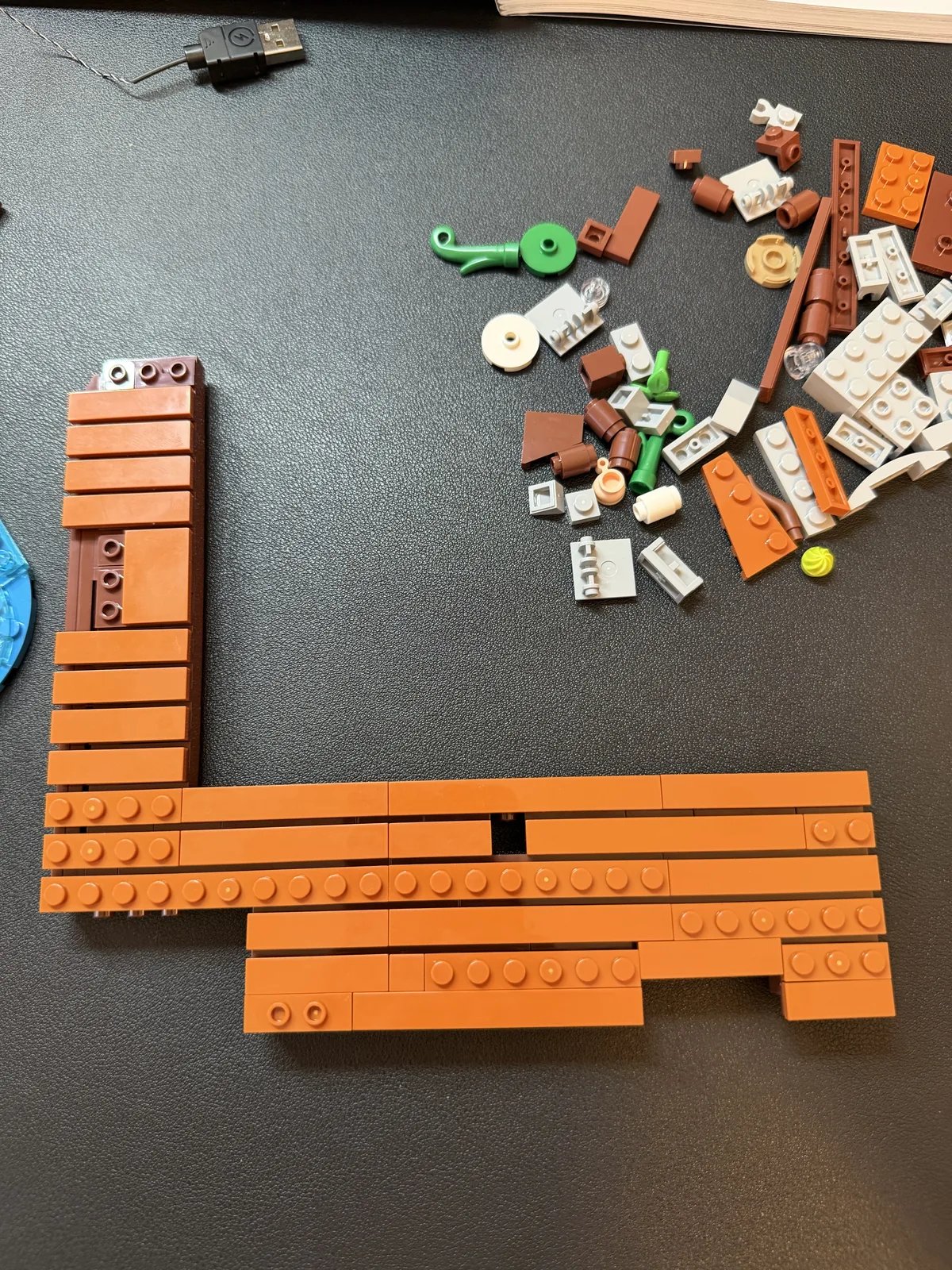 Lumibricks 10010 Waterfall Cabin — cabin deck floor under construction with USB power cable nearby