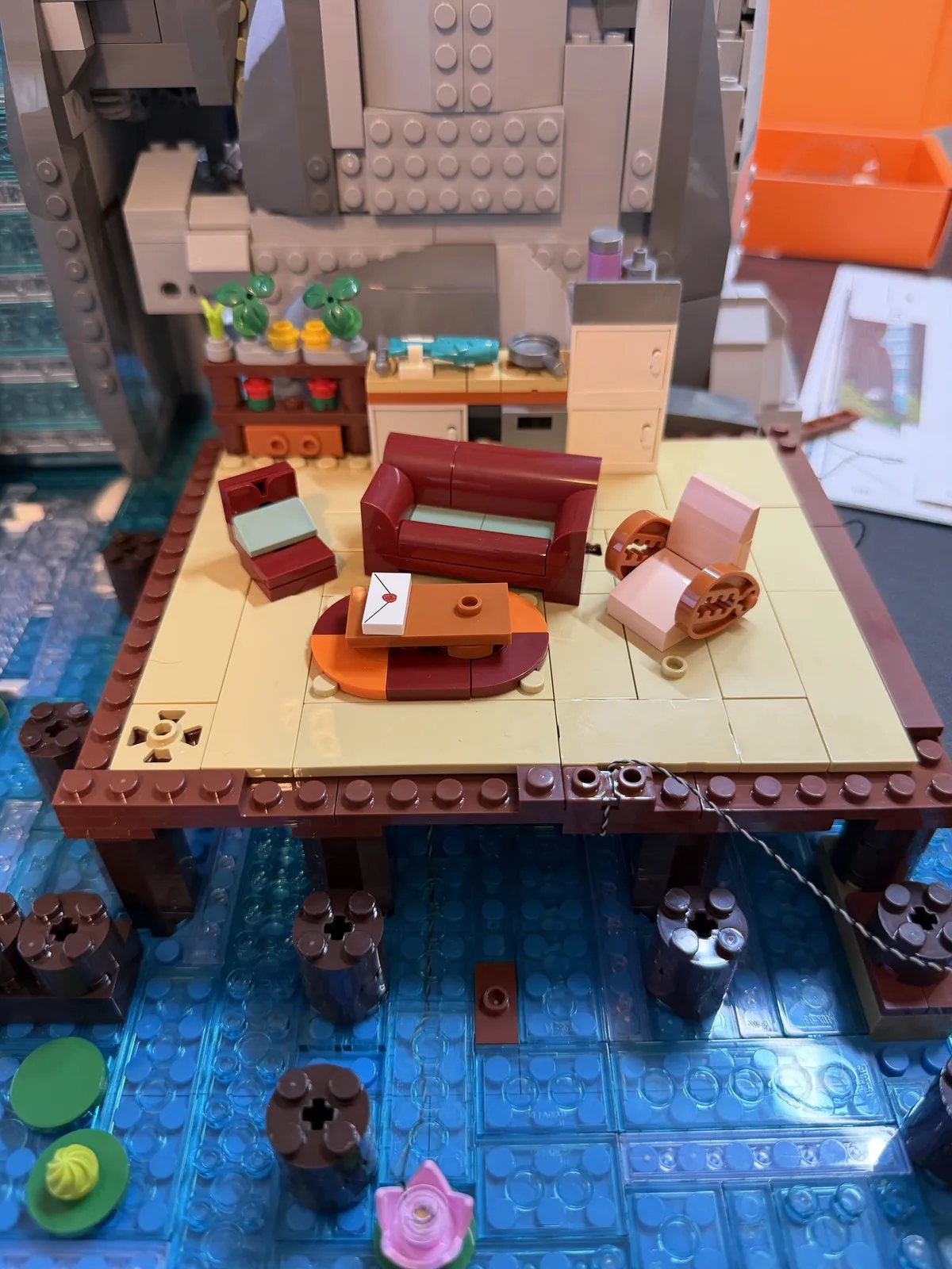 Lumibricks 10010 Waterfall Cabin — first-floor living room and kitchen on the deck over blue water