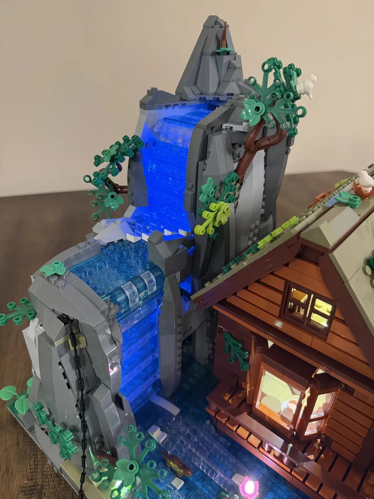 Lumibricks 10010 Waterfall Cabin — high-angle finished build with two-tier glowing waterfall