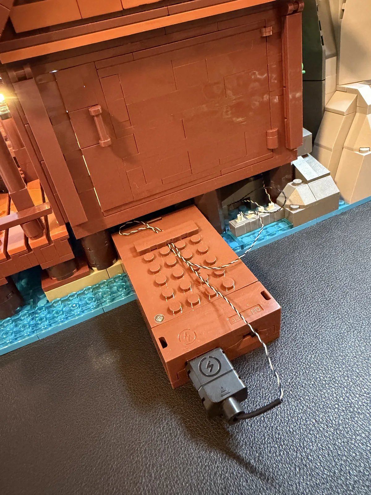 Lumibricks 10010 Waterfall Cabin — side battery box slid out from the cabin base with wiring