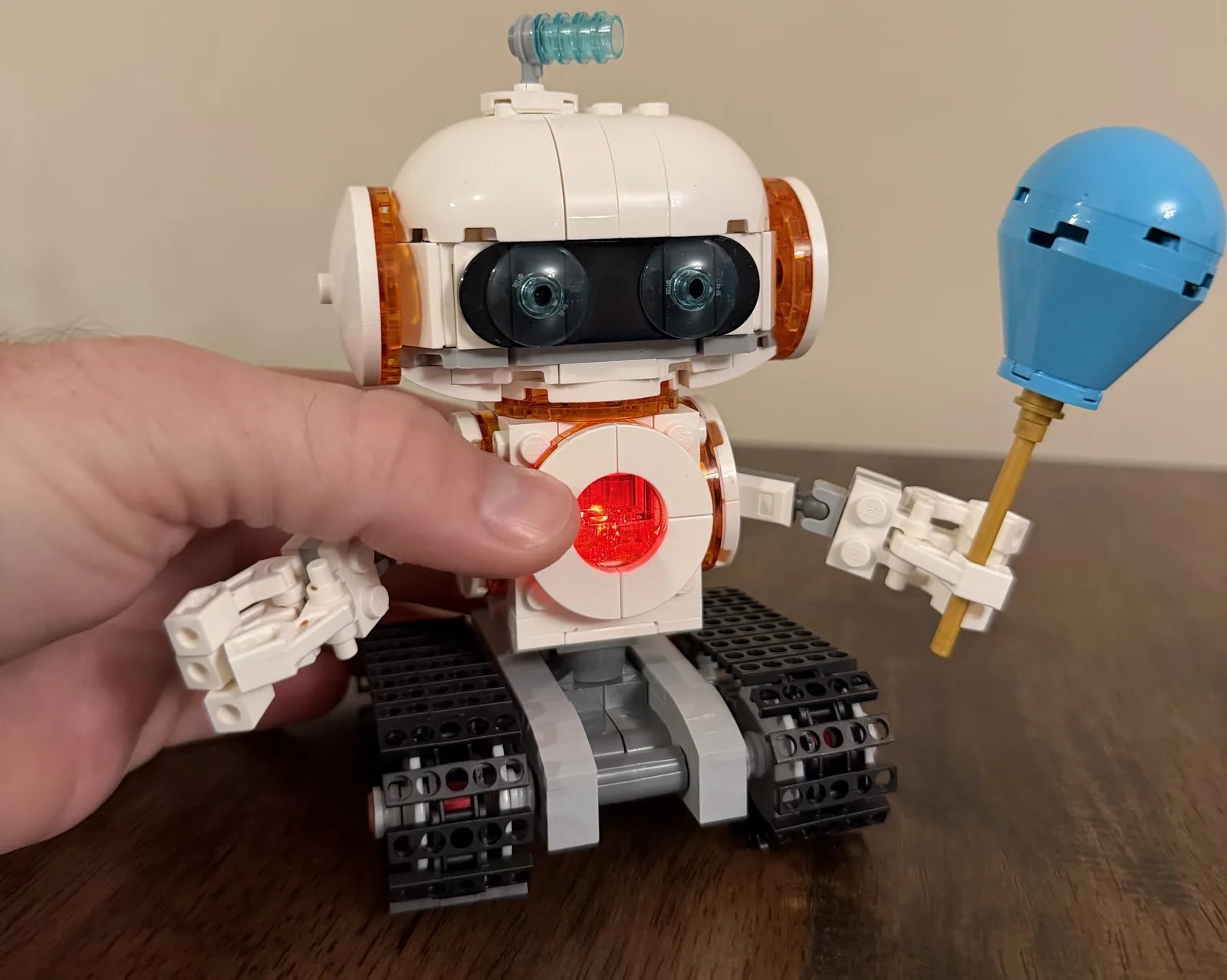 LEGO 31164 Creator 3-in-1 Space Robot — pressing the chest light brick so the robot glows red