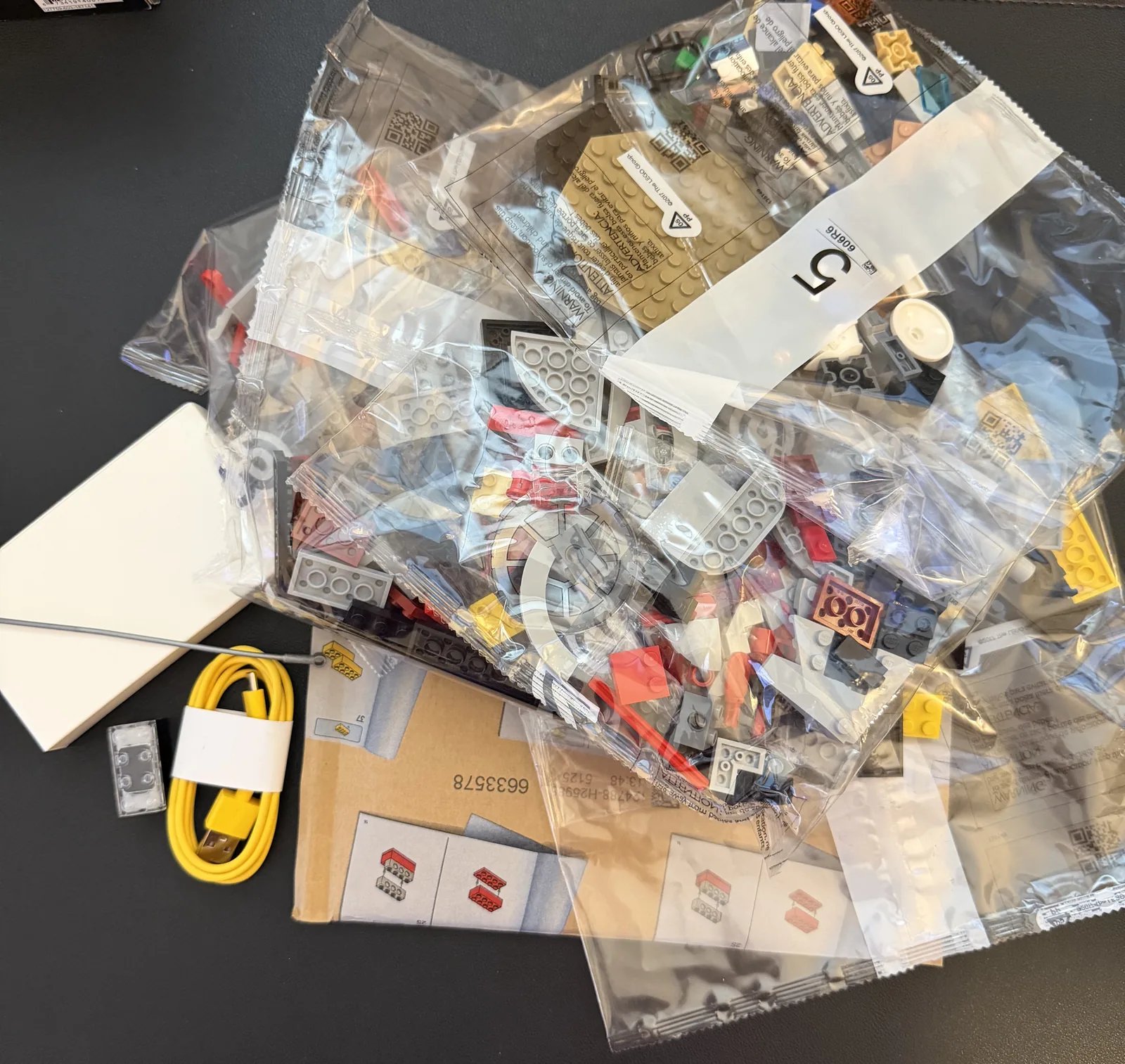 LEGO 75421 Darth Vader's TIE Fighter — box contents laid out with numbered bags, instructions and the yellow USB cable