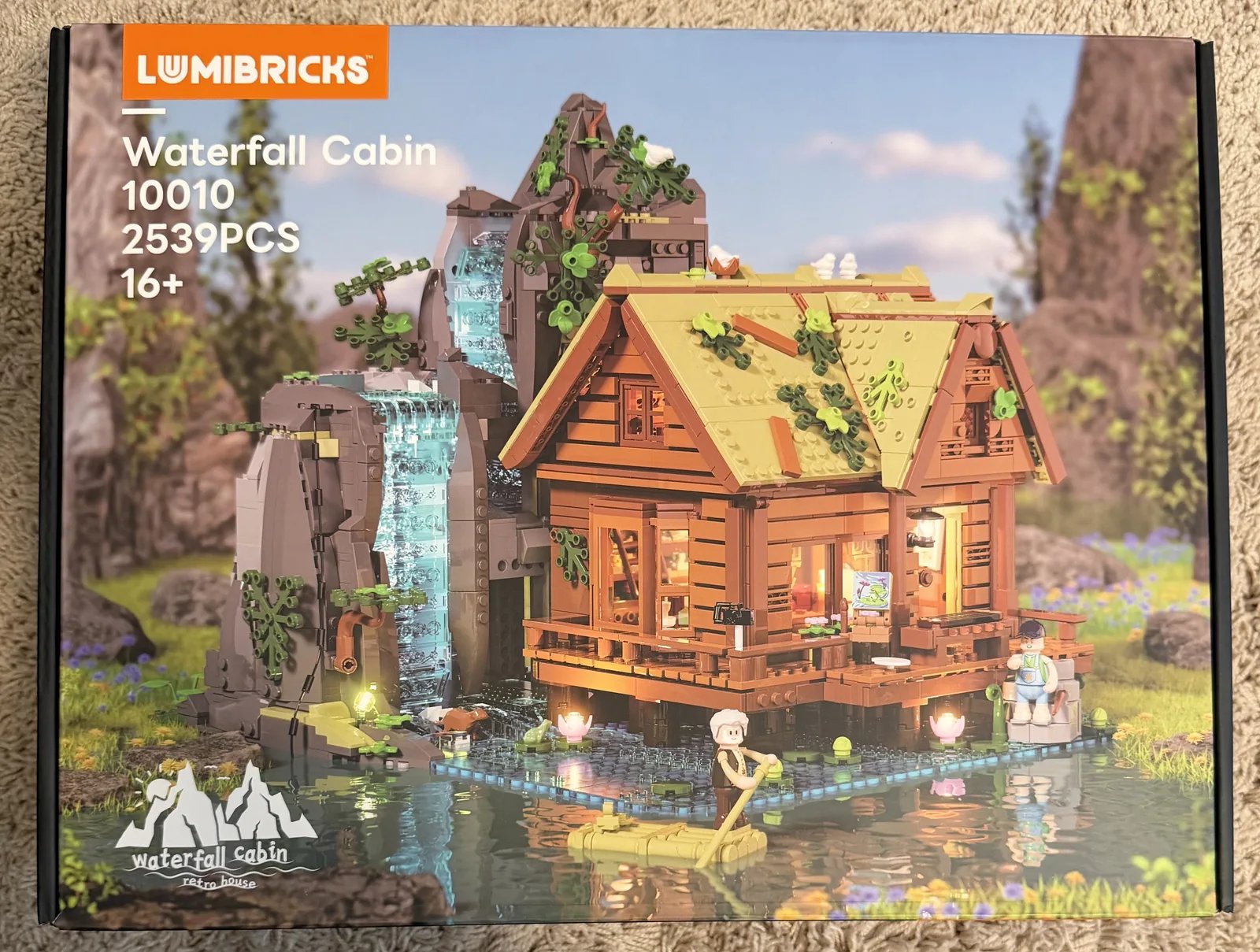 Lumibricks 10010 Waterfall Cabin — retail box front showing the lit cabin and waterfall