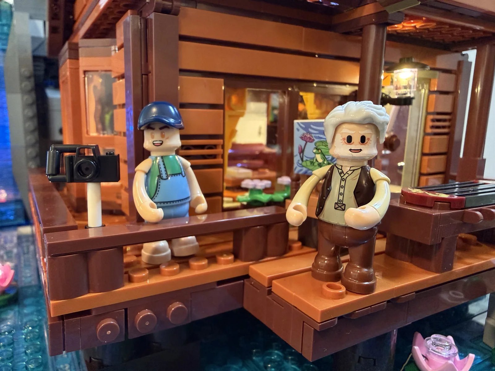 Lumibricks 10010 Waterfall Cabin — minifigures on the porch balcony over the pond