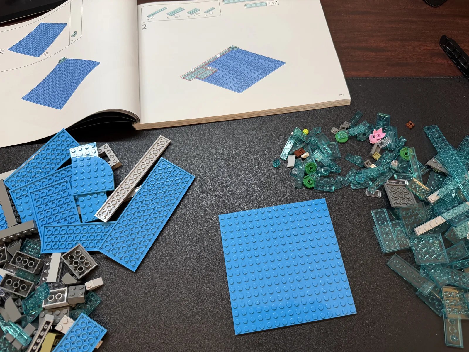 Lumibricks 10010 Waterfall Cabin — early build with open instructions and sorted blue water pieces